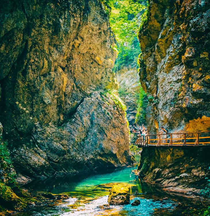 People looking at nature from a bridge in mountains in Slovenia