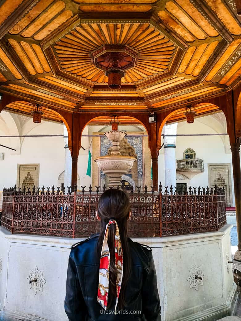 Girl standing in front of well at Gazi Husrev Begs mosque
