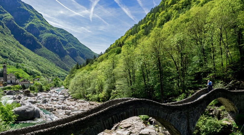 People standing on a stone bridge in Ticino